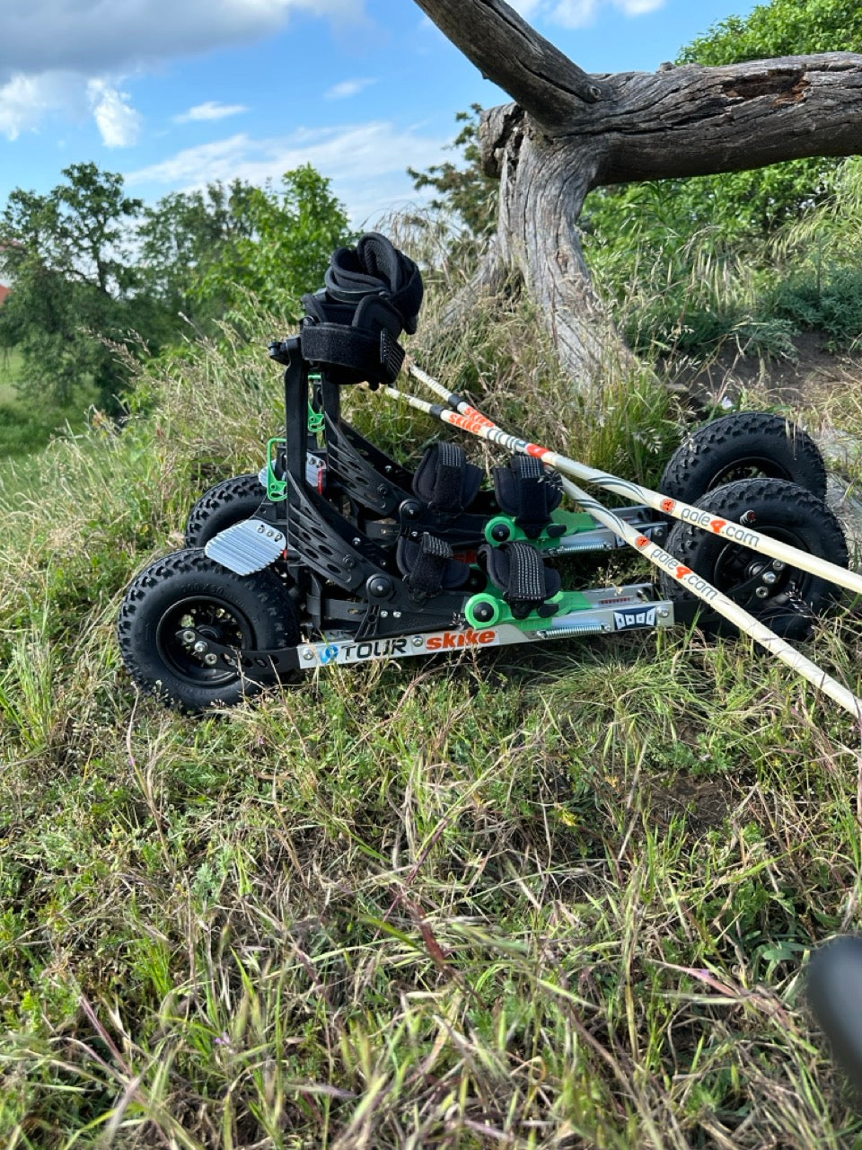 A skike v9 TOUR 200 Cross Skate with one4all 30% adjustable carbon poles propped on it